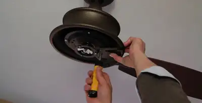 Electrician installing ceiling fan mounting bracket and fixture in Easton, PA