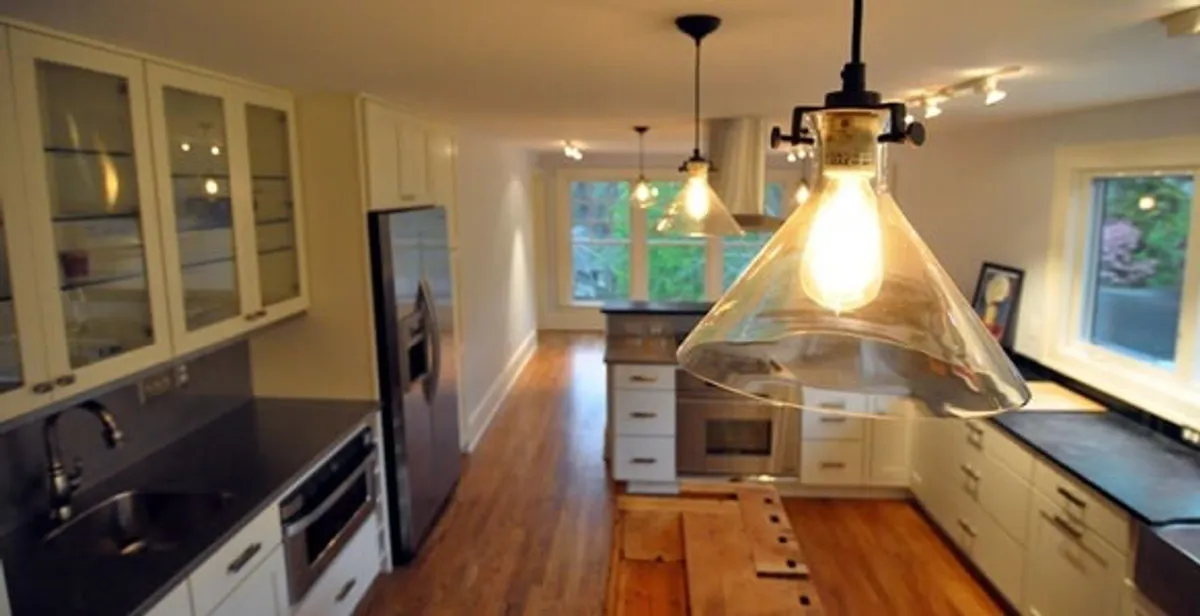 Residential electrician installing modern indoor light fixture in a home in Easton, PA